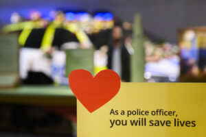 Bilden visar ett hjärta, polismuseet i bakgrunden och text