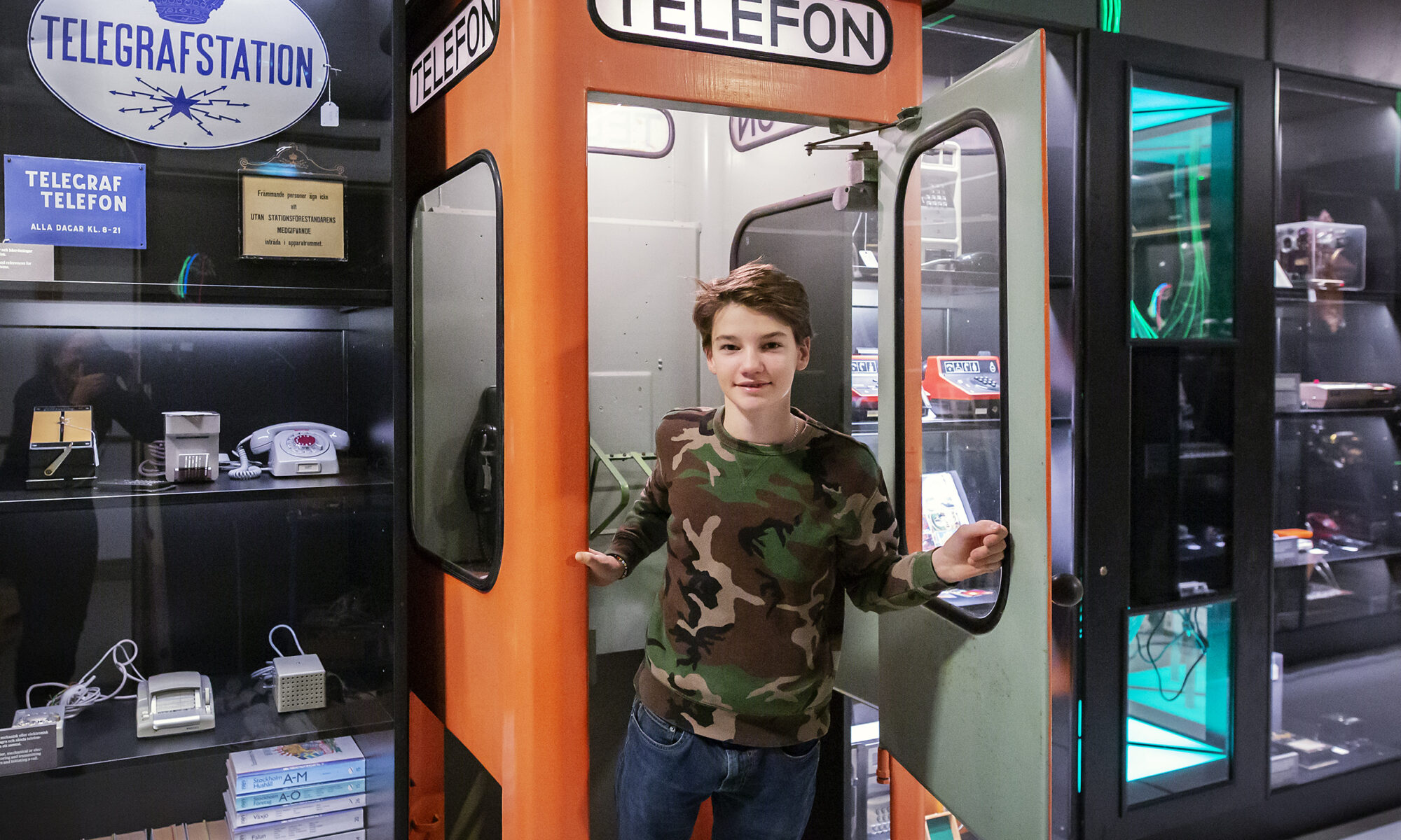 en pojke i en telefonkiosk